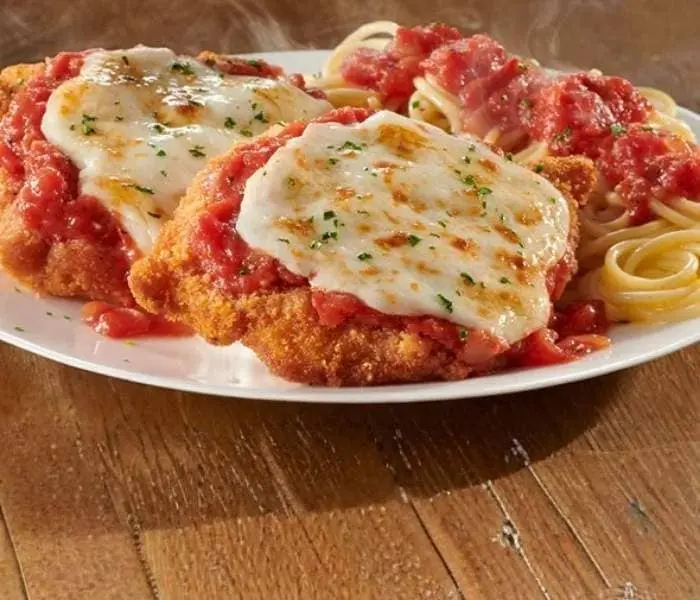 Olive Garden Chicken Parmigiana topped with melted mozzarella and marinara sauce served with pasta