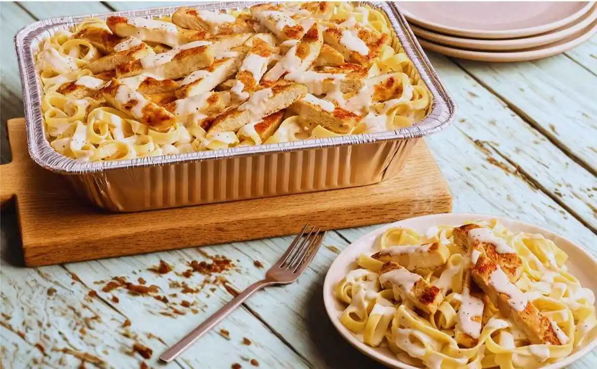 Olive Garden family-size Chicken Alfredo tray served with grilled chicken and creamy Alfredo sauce