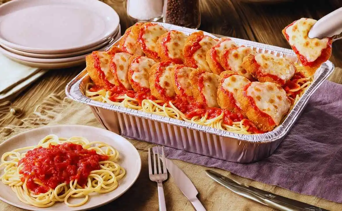 Olive Garden family-size Chicken Parmigiana tray with spaghetti, marinara sauce, and melted mozzarella