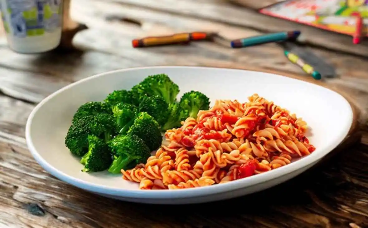 Olive Garden kids rotini pasta with marinara sauce served with broccoli