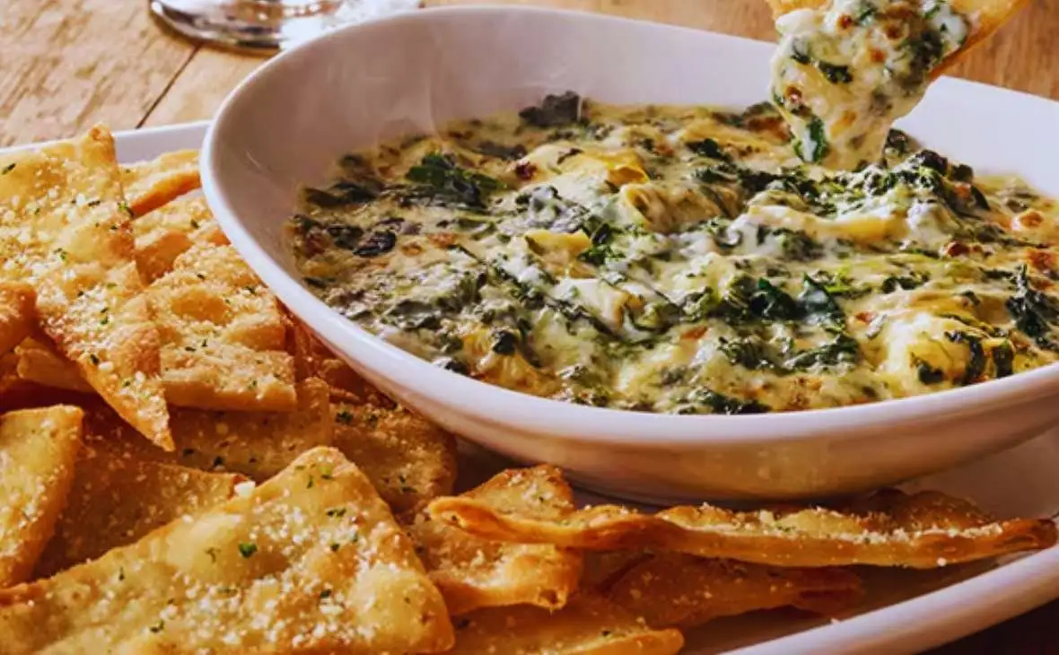 Olive Garden Spinach-Artichoke Dip served warm with crispy tortilla-style chips